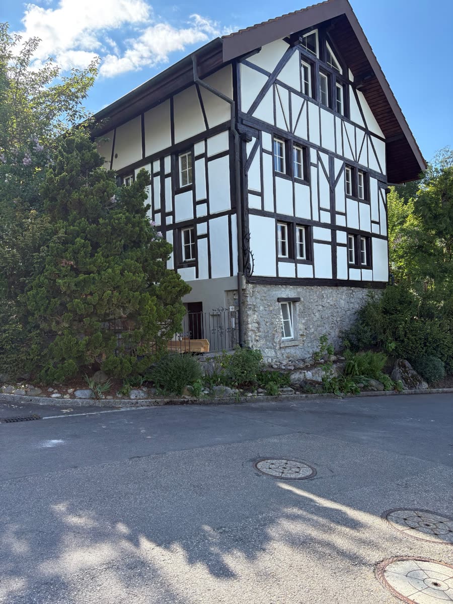 Das Riegelhaus an der Pfaffenhalde 22 in Boniswil — Fachwerkfassade mit umgebenden Bäumen.